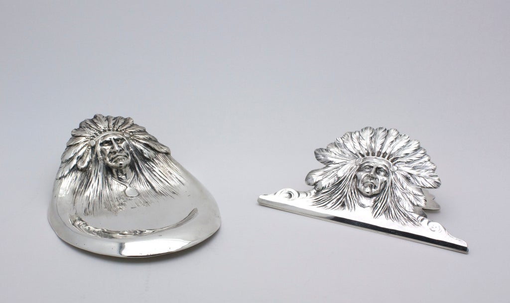 These sterling silver desk accessories depict two unique Native American chiefs with beautifully articulated feather headdresses. The set includes a paper organizer/clip with spring mechanism and matching pen holder and tray. The skill of the