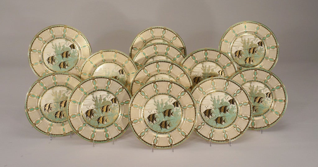 An unusual and whimsical set of 12 Lenox fish plates are not the regular fare. Featuring a mint green, gold and black color combination, these angelfish are in motion, swimmimg through a coral underwater scene. The black and gold palette of fish
