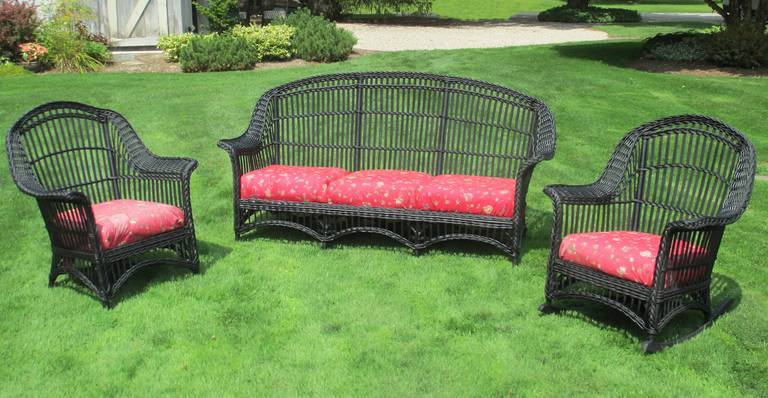 Matching three-piece Stick Wicker set in black painted finish. (can be re-painted any color on request)  Sofa, armchair & rocking chair with high arched backrest.  Hallmark Stick Wicker closely paired vertical reeds along with woven flared arms,