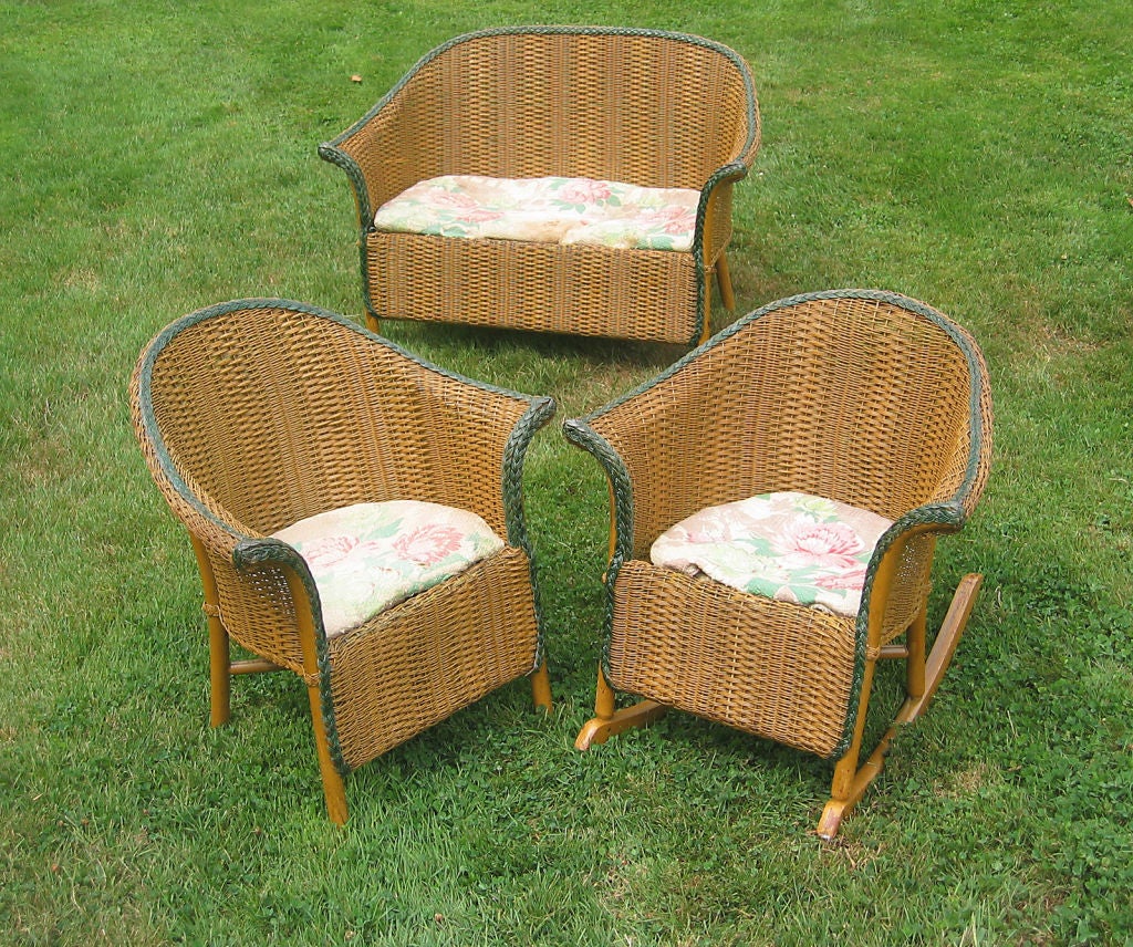 Three piece child's set of antique wicker consisting of matching settee, armchair and rocking chair. Original natural stained finish with worn green painted detailing along braided borders. Art Deco style with closely woven repetitive pattern