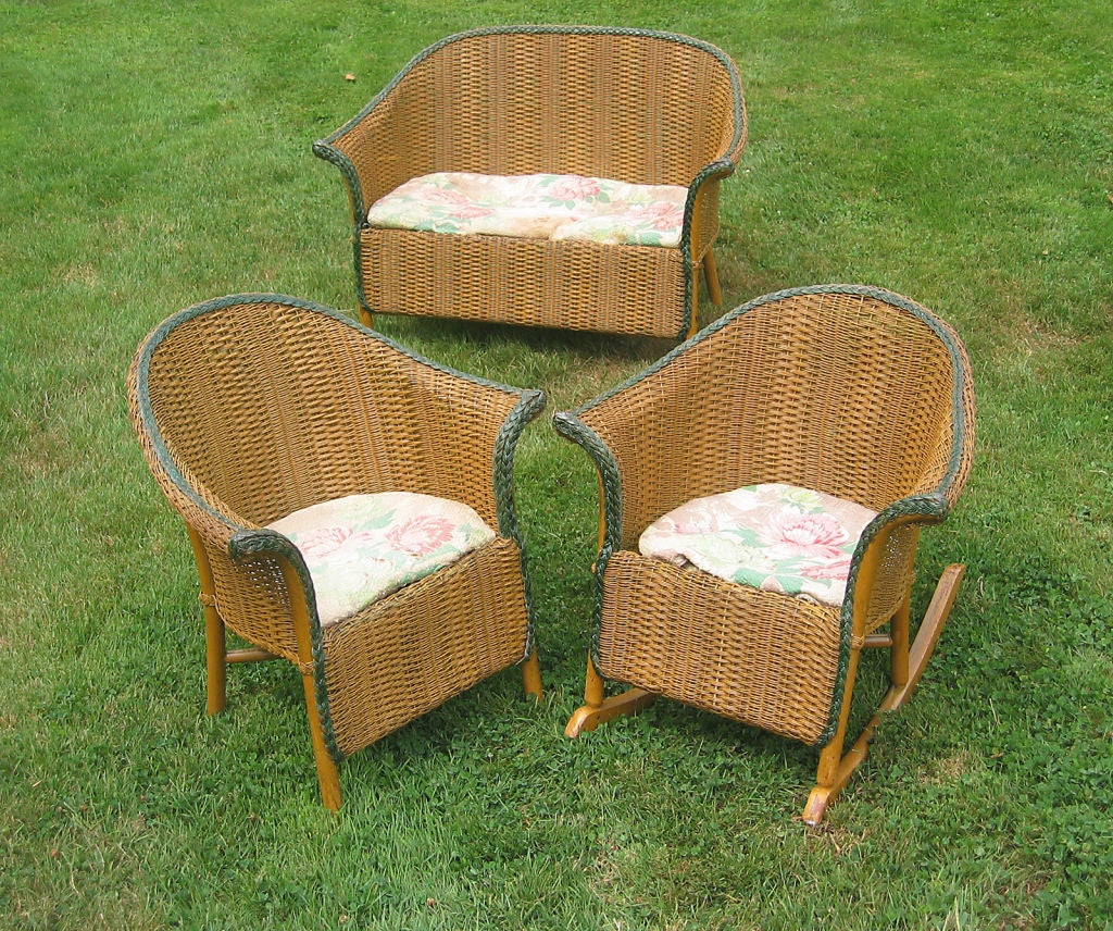 Three piece child's set of antique wicker consisting of matching settee, armchair and rocking chair. Original natural stained finish with worn green painted detailing along braided borders. Art Deco style with closely woven repetitive pattern