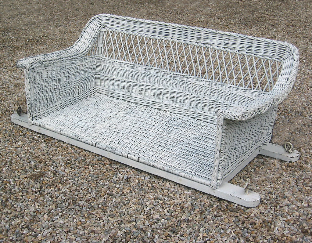 Bar Harbor wicker swing in old white painted finish. (can be re-painted any color on request) Traditional crisscrossed open latticework combined with densely woven sides and lower back. Wide flat arms. Made of willow, woven seat platform.