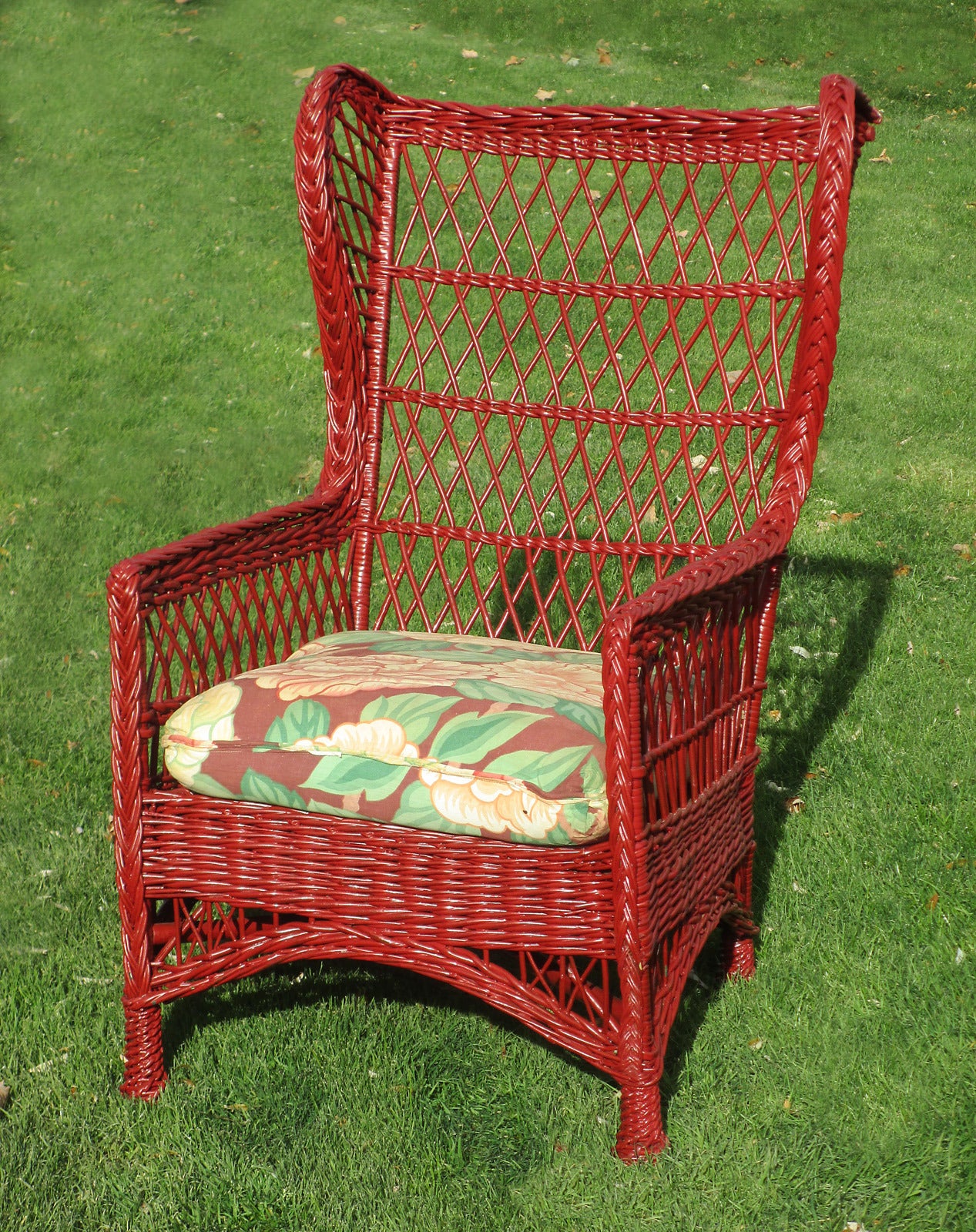 Bar Harbor wingback armchair in red painted finish. Criss-cross latticing overall. High level back, braided arms, and four pineapple feet.