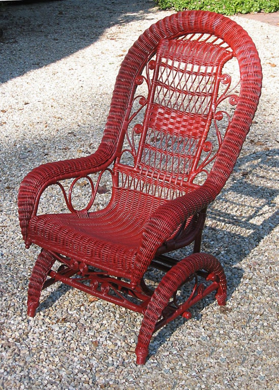 Wicker platform rocking chair, circa 1890s.  Original bent metal rods provide the smooth back & forth rocking movement in place of long curved wooden runners.  Serpentine rolled border and base with curlicues and handwoven fancywork on backrest. 