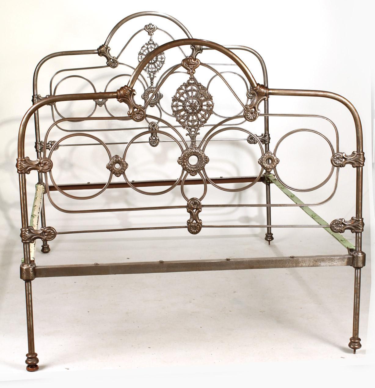 Cast in iron, this bed has all the elegance of that far away era, decorated with medallions and circles. The railings and stretchers of the head and foot boards have widely spaced flat-headed pegs to which cording may be attached to hold a double