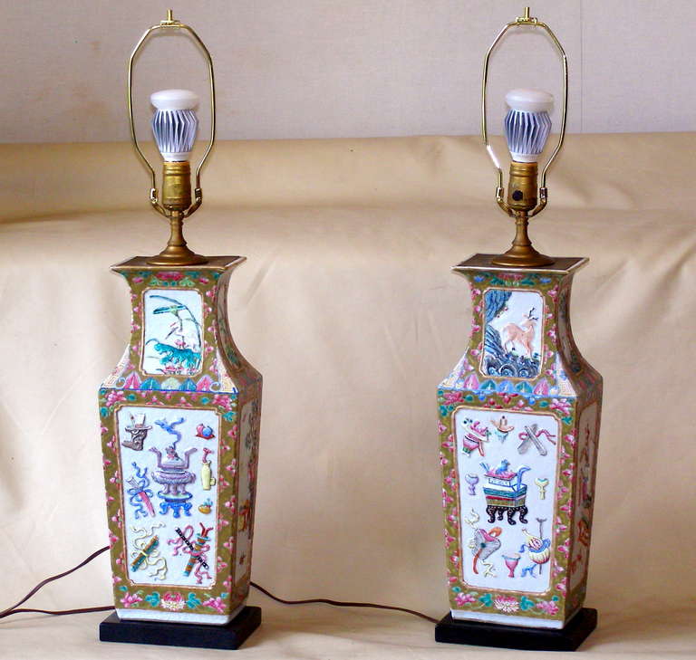 A very high quality pair of sculpted porcelain vases depicting numerous precious objects and naturalistic subjects. The enamel colors are bright and festive. These look to have been converted to lamps about 50 years ago. The lamp cord is still