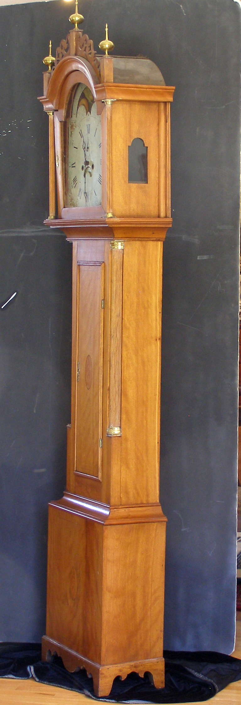 A very attractive light amber inlaid wavy birch New England tall clock probably made in the Concord New Hampshire region. The movement is an eight day time and strike (on the hour) with moon phases dial and date of the month window. The back of the