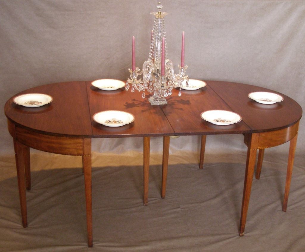 A nice small banquet table that can also be used as two console tables. It is in a remarkably good state of preservation with a very old but pleasing finish. The bottom edge of the frame has a patterned modified lunette inlay and the bottoms of the