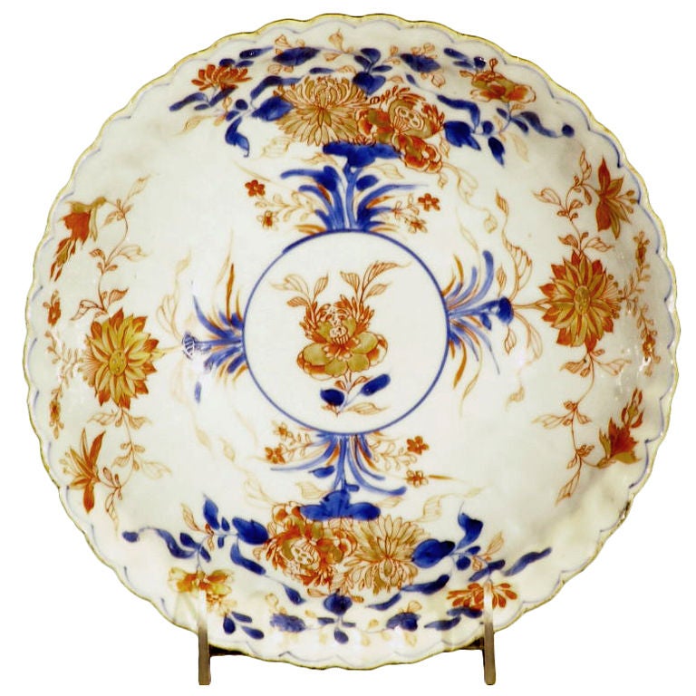 A delicately decorated Chinese Imari colored and gilded thinly potted porcelain bowl. The body of the bowl has closely spaced ribbed  modeling ending in the scalloped edge. The gilding is in a remarkably good state of preservation.