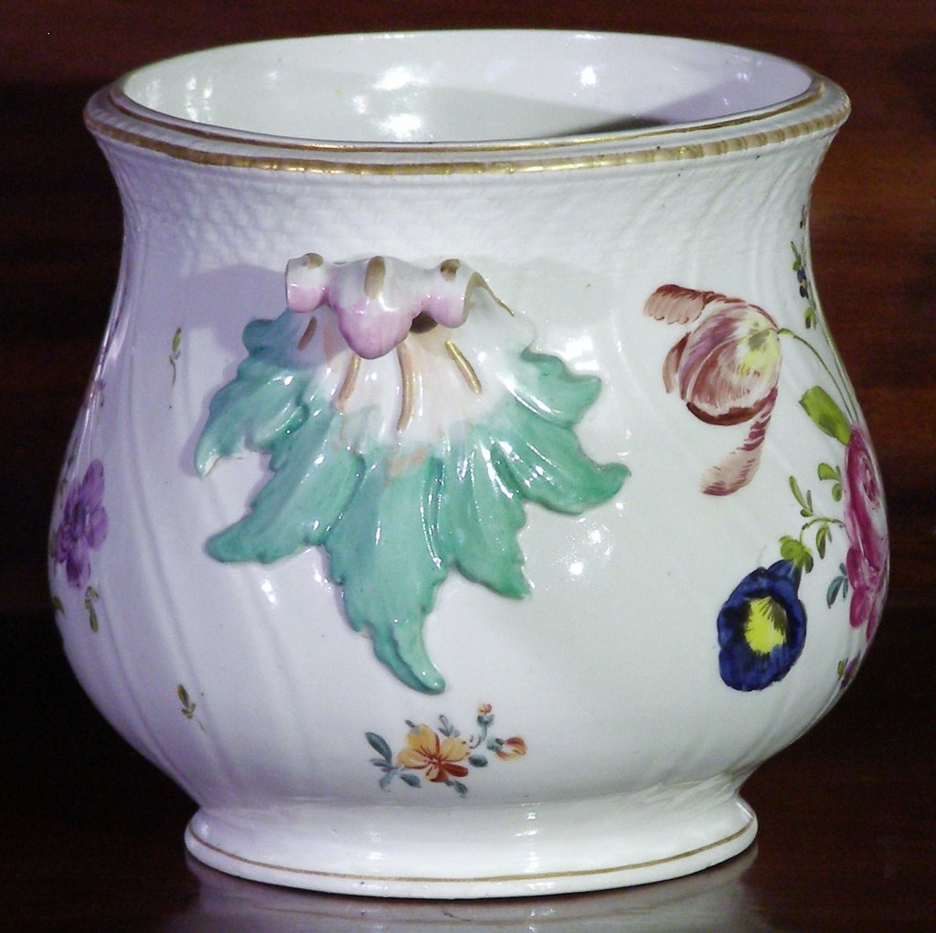 A very attractive European porcelain cache pot with all over floral decoration, swirl fluting and basket weave modeling. There are roses, tulips, daisies,  a morning glory, peony etc. The handles are in a bold rococo style. I do not recognize the