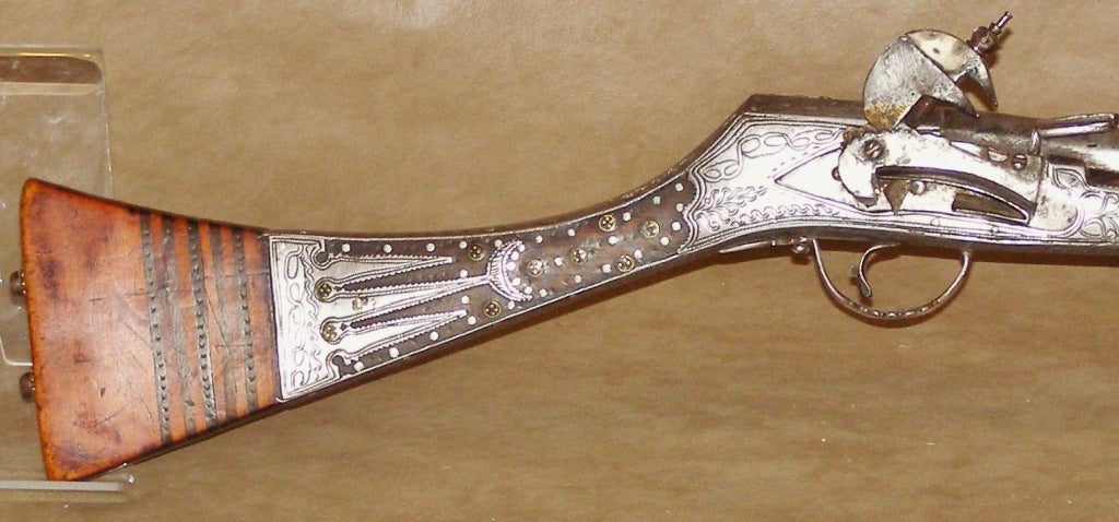 While not adorned with precious metals or jewels this decorative
long gun has lots of careful workmanship. Aside from the barrel and firing mechanism just about everything else has engraving or decorative studs. The firing mechanism appears to be