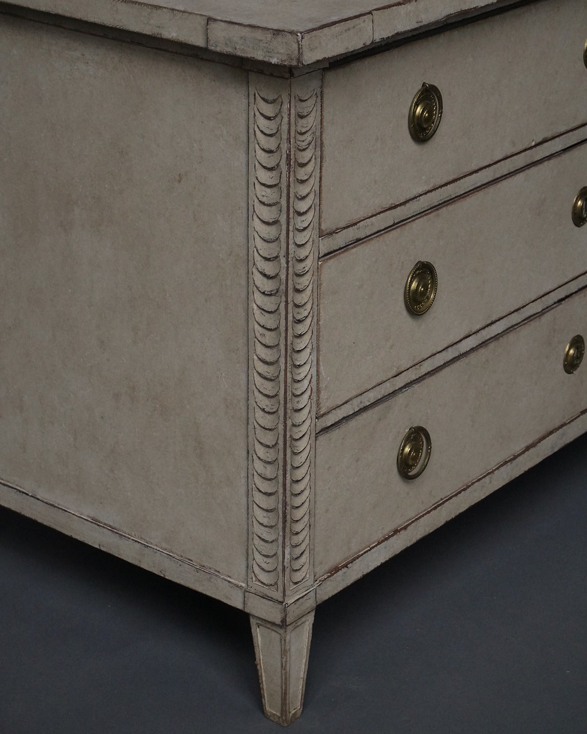 Late Gustavian chest of drawers, Sweden, circa 1830, with fish scale carving at the corners. Shaped top and brass hardware.