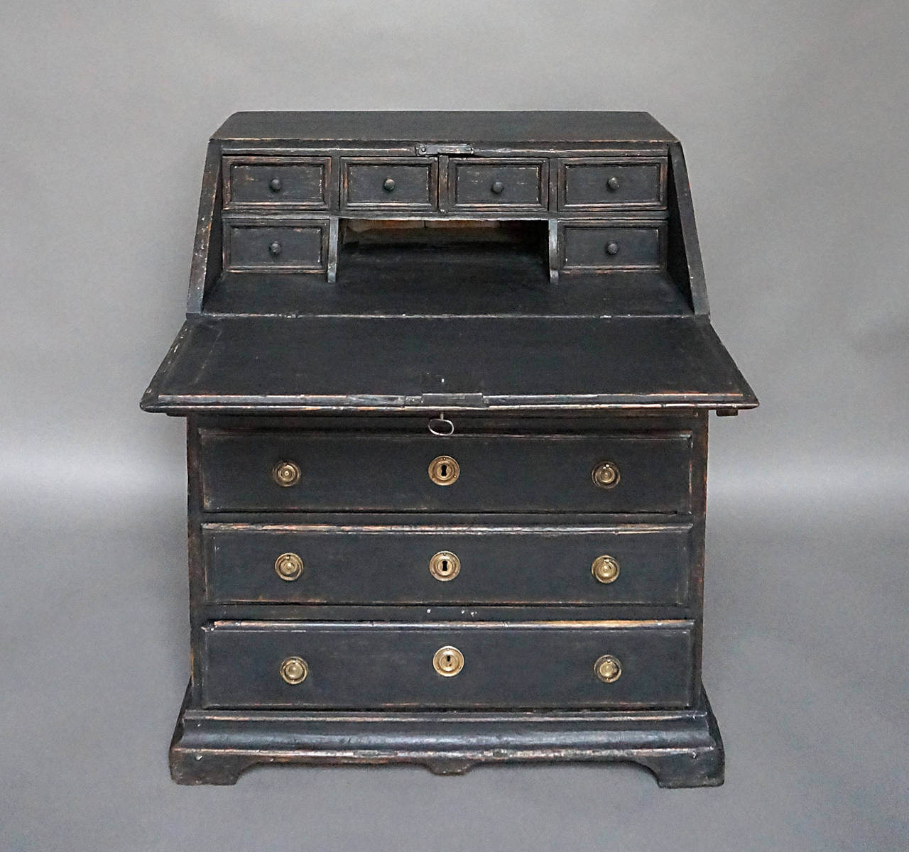 Early Swedish slant front writing desk, circa 1760, in a small size. Four full width drawers below the writing surface, and six small drawers inside, all on a shaped bracket base. Original brass hardware.