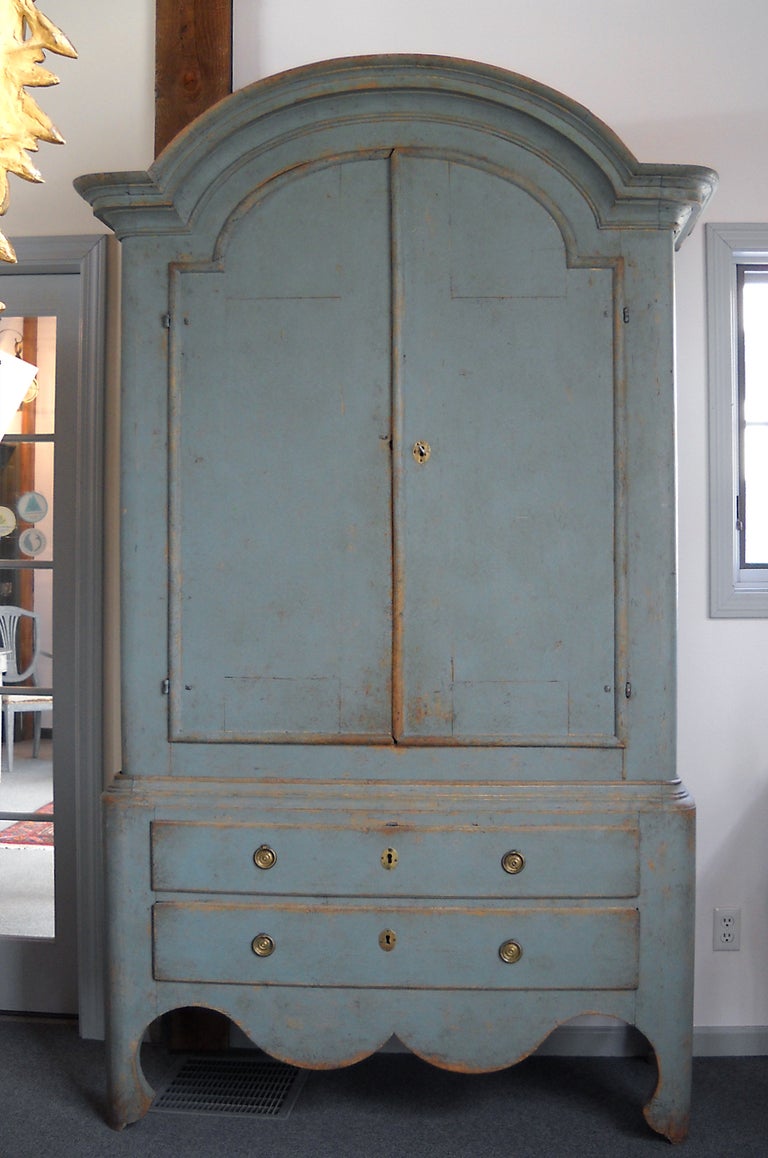 Large period cabinet with two drawers from Jåmtland, Sweden, circa 1760. This rural interpretation of the rococo style features an arched pediment, curvy bracket feet, and aprons with exaggerated form on the front and sides. The interior has four