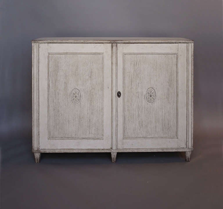 Period Gustavian sideboard, Sweden circa 1800, signed ES (Ephraim Ståhl, active in Stockholm 1794-1820). Two reeded doors with center medallions open onto two shelves and two drawers. Classic proportions.