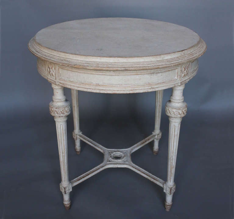 Round side table, Sweden circa 1910, in the Gustavian style. Wide apron with florets above legs with guilloche carving which are joined by a saltire stretcher.