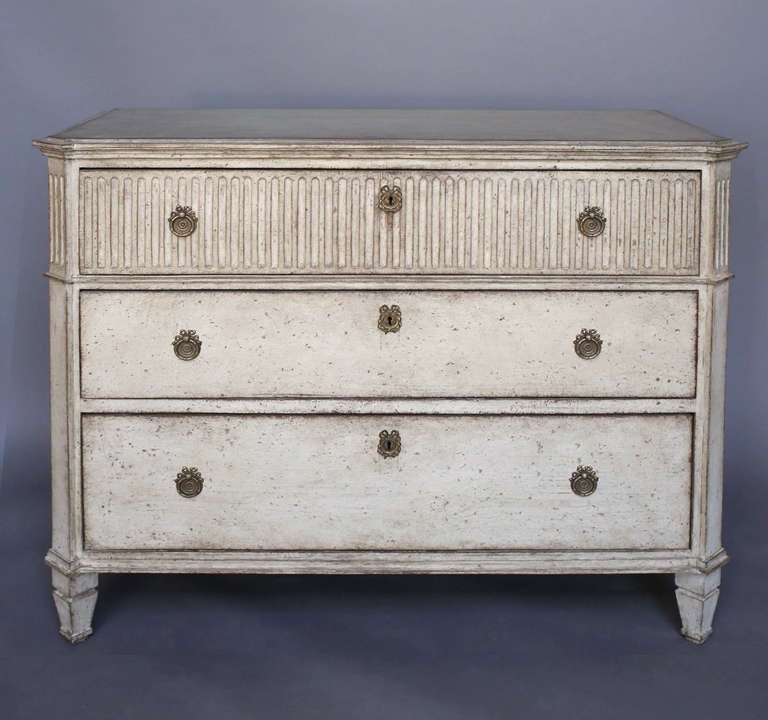Period Gustavian chest of drawers, Sweden circa 1800, with fluting across the front of the top drawer and around the sides. Canted corners, shaped black top, and tapering square legs.