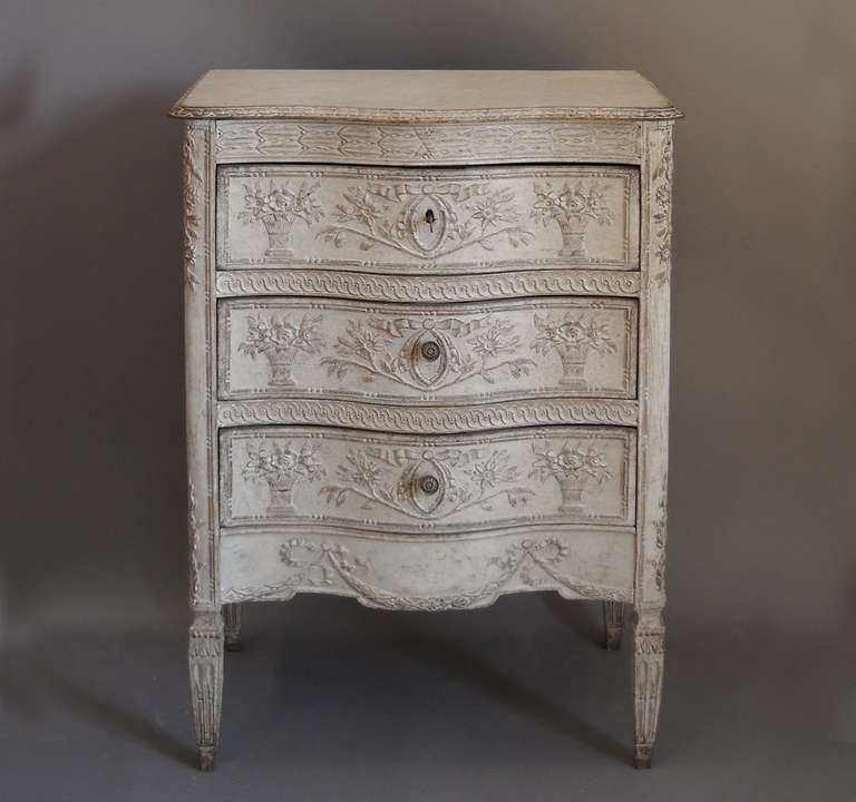 Small chest of drawers, France circa 1880, with floral carving on drawer fronts and curved corner blocks. Additional leaf and berry carving surrounds the shaped top, and each leg is topped with carved tassels.