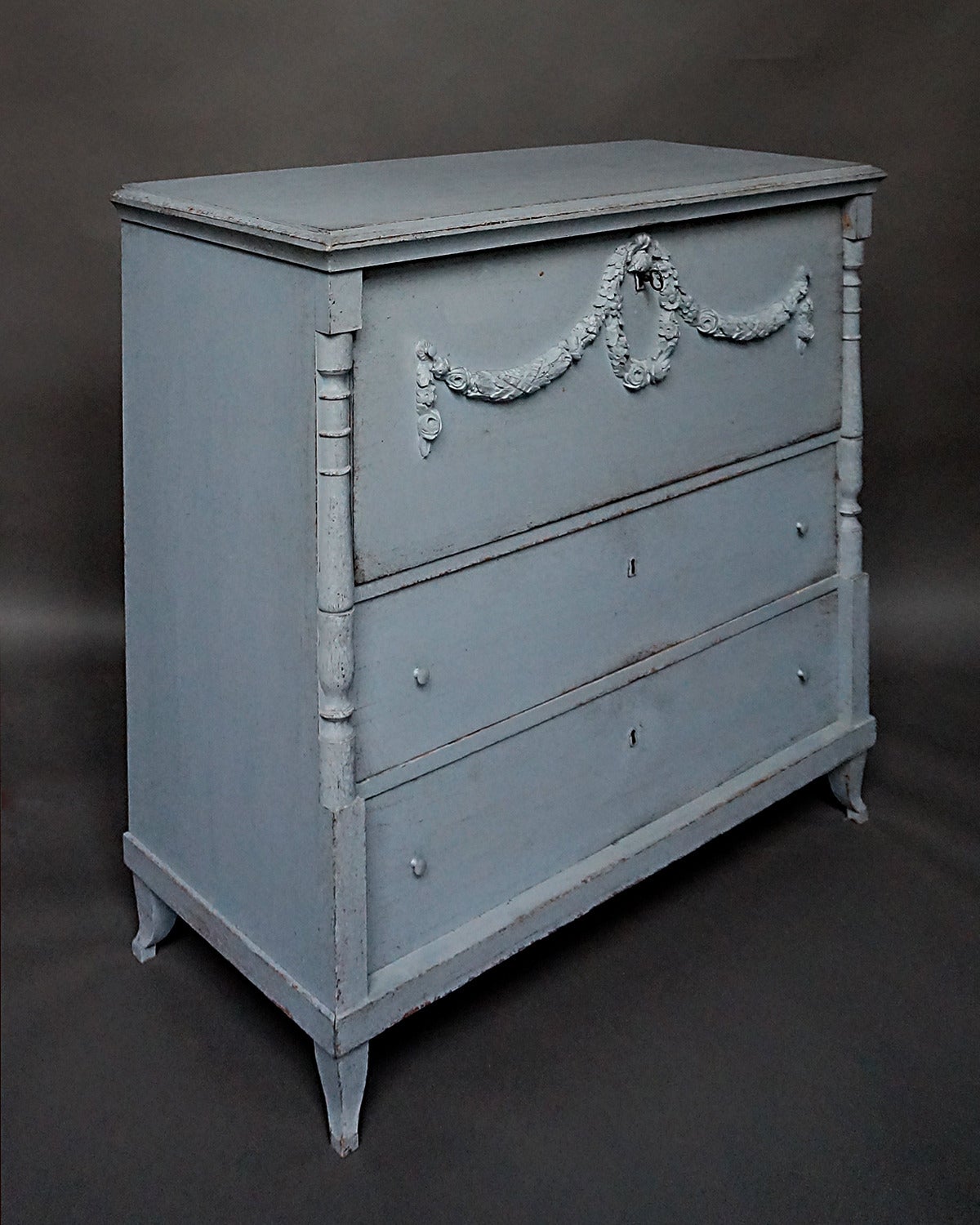 Period neoclassical chest of drawers, Sweden circa 1830, with applied laurel wreath and swags on the top drawer. Turned half-columns at either side above flaring French feet. Inside the top drawer are another three small drawers.