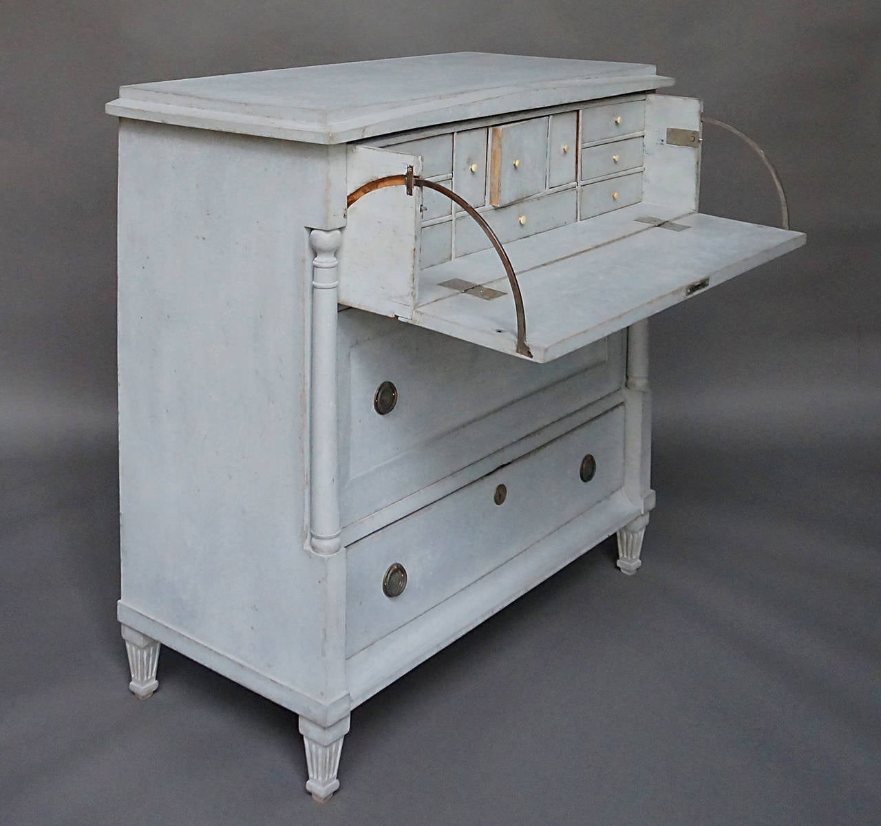 Swedish butler's desk with two drawers, circa 1850. The writing surface and fitted interior is concealed behind a false drawer front. Simple neoclassical design with shallow pediment at the front and columns at either side. Brass hardware.