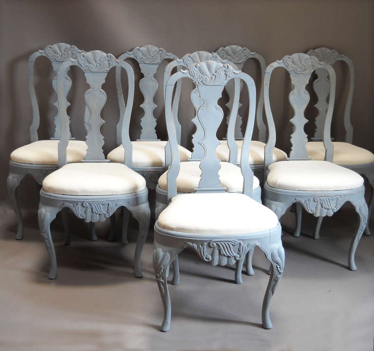 Set of eight dining chairs, Sweden circa 1880, in the rococo style with slip seats and elaborate carving.