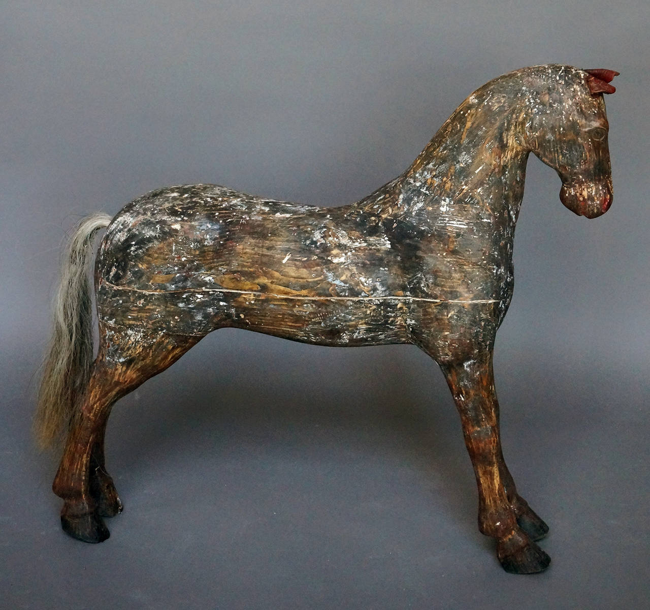Tall carved horse, Sweden circa 1900, scraped to its original painted surface. Leather ears, painted mane, and horsehair tail.