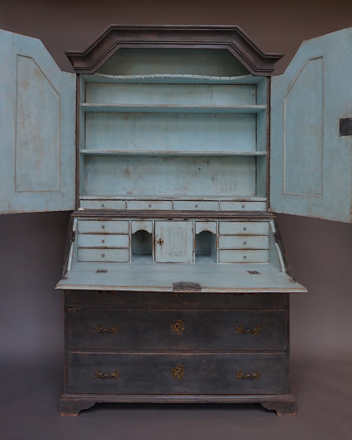 Period Swedish secretary, circa 1810 having raised panel doors with reeded detail. The lower section has a fitted interior with disguised drawers and a locking compartment, all-over three drawers and bracket base. Beautiful Rococo brass hardware on