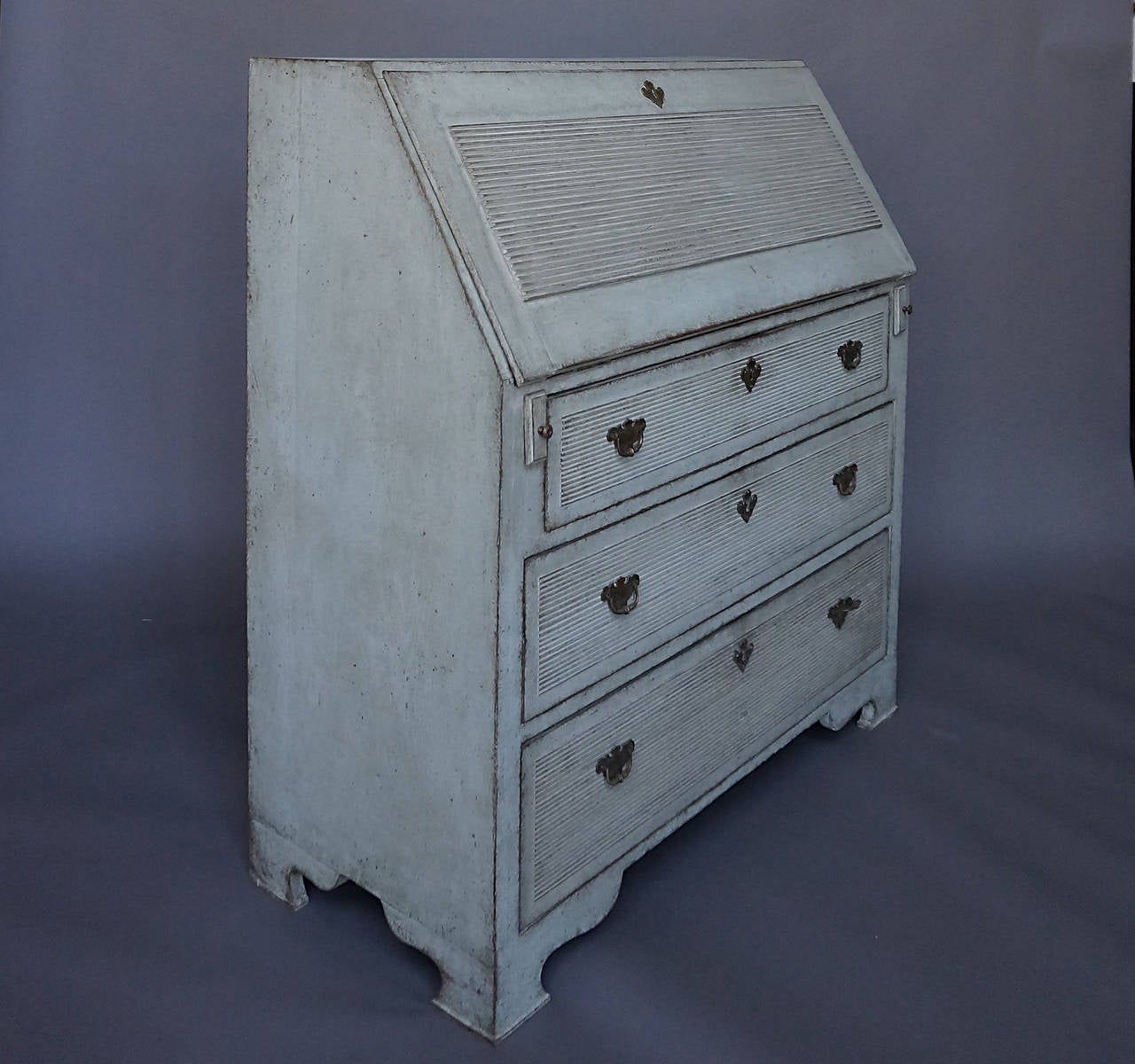 Writing desk in the Gustavian Style, Sweden, circa 1880. Raised, reeded panels on the three-drawer fronts and on the slant front. The interior is fitted with drawers and compartments. Shaped bracket base. Height to writing surface 33 inches.