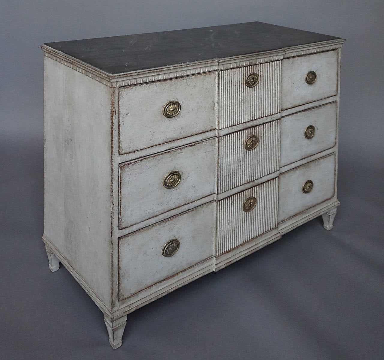Neoclassical chest of drawers, Sweden circa 1840, with dentil molding under the shaped top and a central panel of reeding on the drawer fronts.