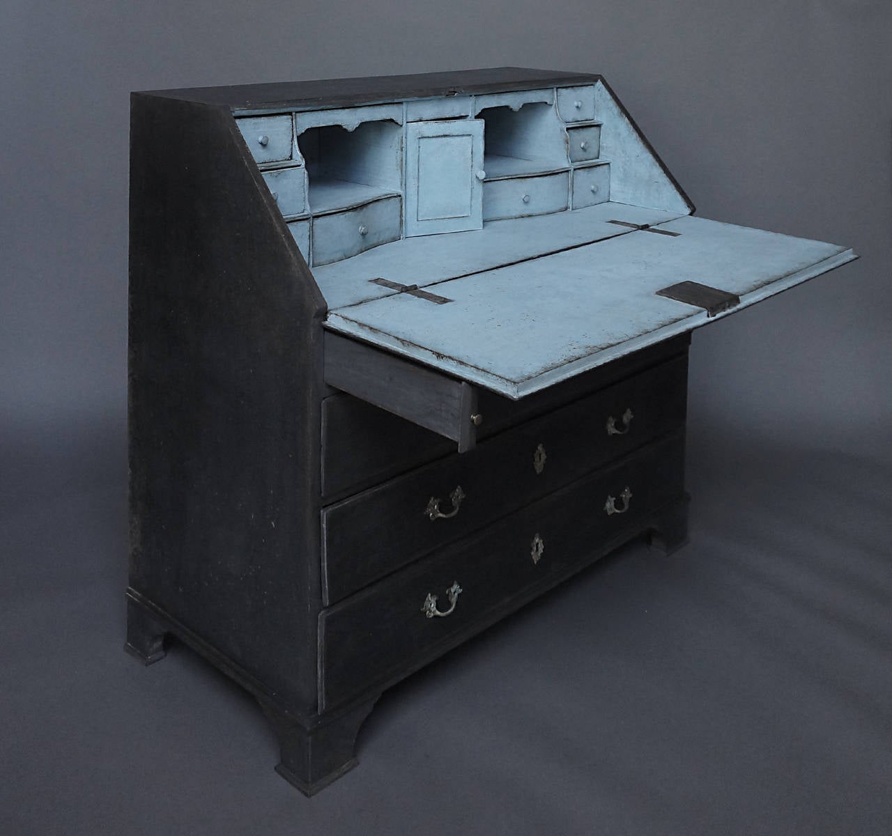 Slant front writing desk in black paint, Sweden, circa 1830. Fitted interior with drawers and compartments, and a book support on the exterior. Two over three drawers on a bracket base.