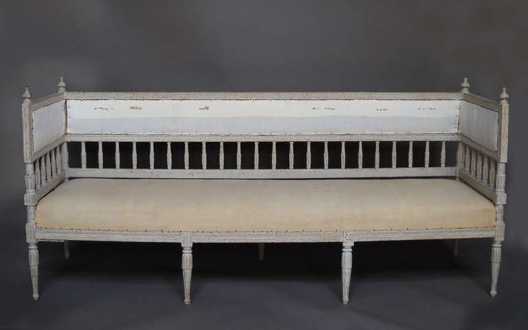 Period Gustavian sofa, Sweden circa 1780, retaining its original painted surface. Balustraded back and sides below upholstered panels and carved finials at the corners. Lovely lambs-tongue and lotus carvings throughout.