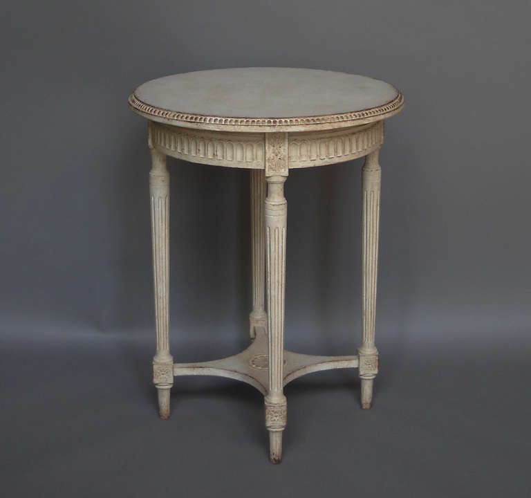 Round side table in the Gustavian style, Sweden circa 1910, with shaped top, tapering legs, and a platform stretcher with central floral motif. From a private collection.