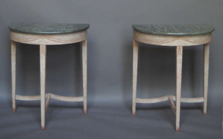 Pair of demilune tables, Sweden circa 1900, with Kolmård marble tops from Östergötland and made for the Kordiska Kompaniet (NK). Nicely carved aprons with a pattern of swags,and legs with lotus flowers.