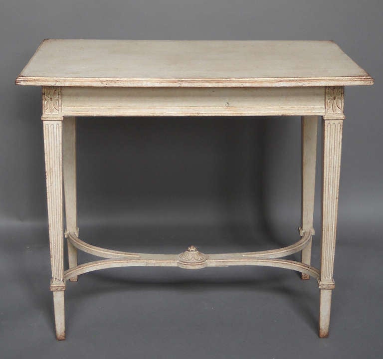 Side table in the Gustavian style, Sweden, circa 1900, having gracefully curving stretchers with a carved central boss. Carved corner blocks above the tapering square legs.