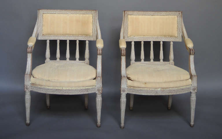 Pair of Swedish fauteuils in the Gustavian style, circa 1900. Curved and upholstered backs and nicely carved detail throughout. Loose seat cushions.