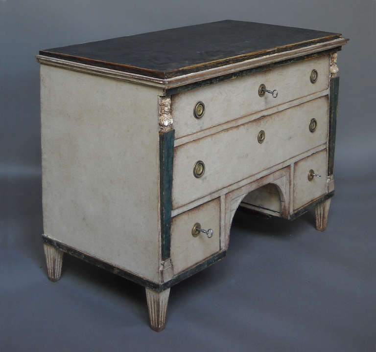 Transitional chest of drawers, Sweden circa 1790, with both Gustavian and neoclassical elements. Corner columns surmounted by applied Egyptian busts terminate in tapering, reeded legs. Unusual form with a disguised compartment behind the cut away