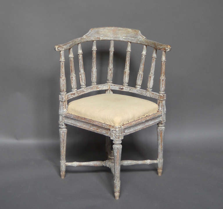 Desk - or corner - chair, Sweden circa 1780, scraped back to its original paint. Seven turned spindles support the rounded back with subdued comb and demonstrate this form's relationship to the English Windsor. Turned legs and crossed stretchers