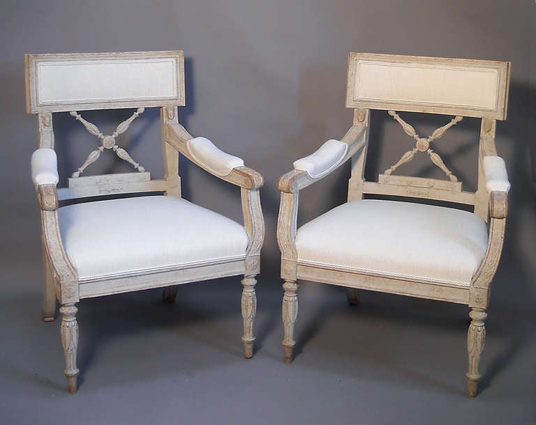Pair of Swedish neoclassical armchairs from the Empire period, circa 1860, with upholstered seats and backs. Carved Egyptian motifs include lotus flowers and archaic heads. Excellent original condition with new upholstery.