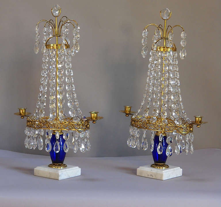 Pair of crystal girandoles, Sweden circa 1910, with cobalt elements above the marble bases. Brass frames with two candle holders in each.