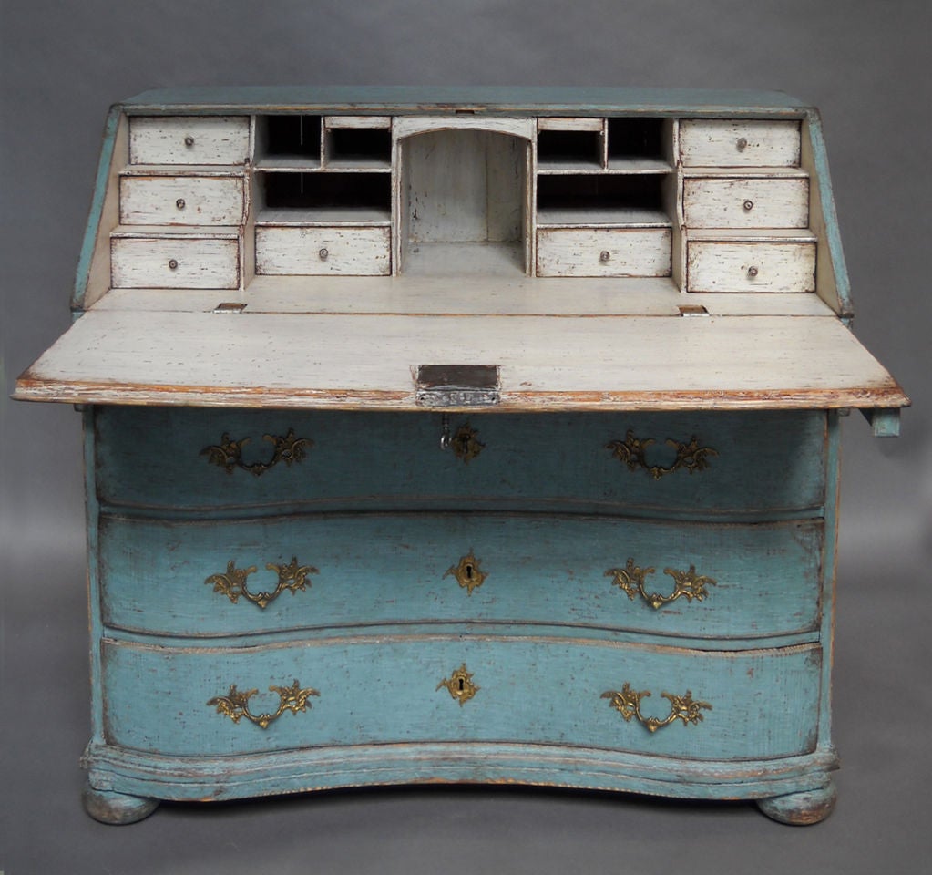Period Swedish rococo writing desk, circa 1760, with original hardware and secondary blue paint. Three drawers in the bowed front with a smaller drawer just under the drop leaf. The interior features two banks of three drawers on either side, as