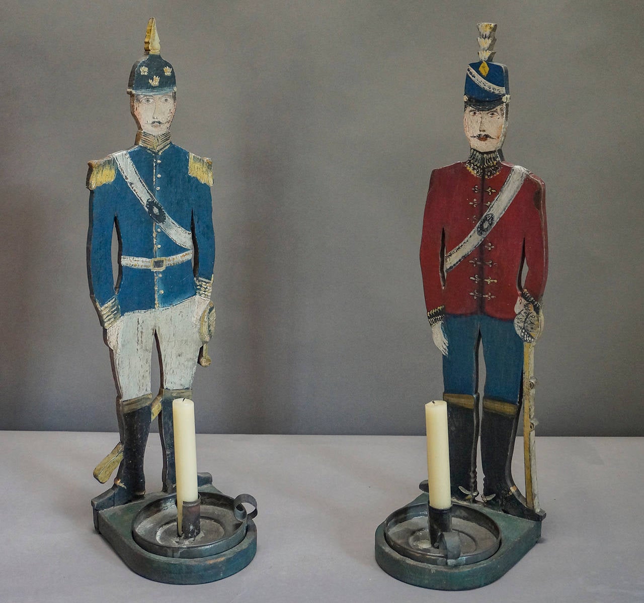 Pair of hand-painted wood soldiers on stands, Sweden, circa 1880. Each holds his own tin chamberstick. Charming example of Swedish Folk Art.
