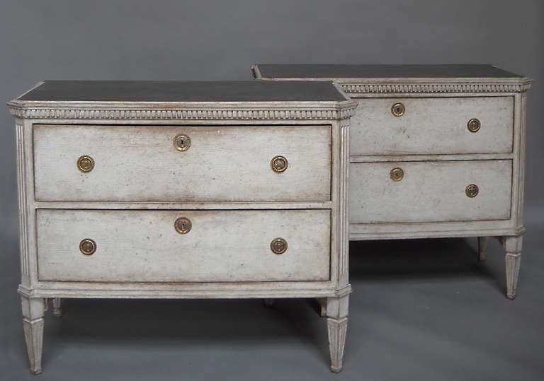 Pair of chests of drawers in the Gustavian style, Sweden circa 1880. Dentil molding around the top, canted corners with fluting, and tapering square legs. Brass hardware and black painted tops.