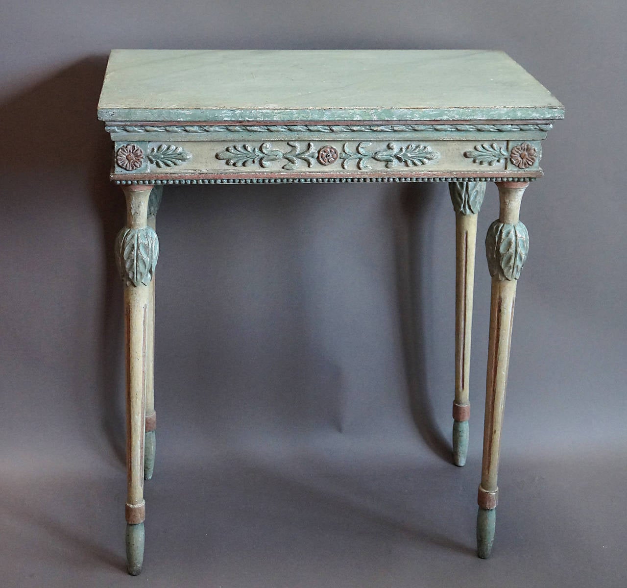 Small neoclassical console table, Sweden, circa 1810, with its original polychrome painted surface. Marbled top with ribbon molding and apron with palmettes and rosettes below. Tapering legs with acanthus leaf detail at the top and elongated bulb