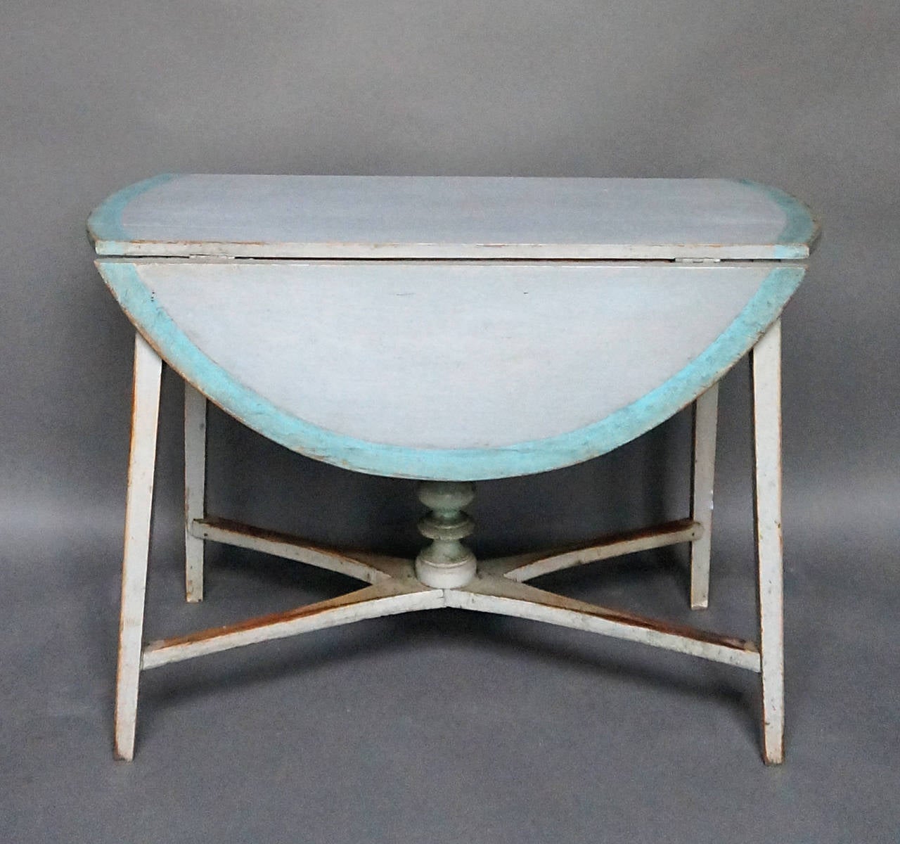 Swedish drop-leaf table, circa 1820, with a saltire stretcher with bold central finial. Original paint with charming detail.