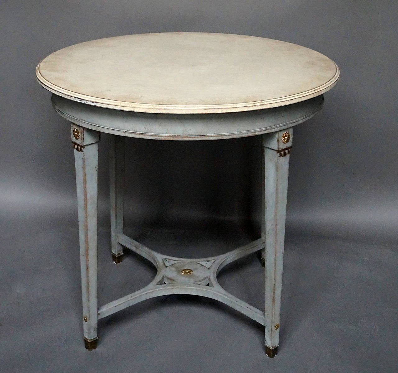Round side table, Sweden circa 1880, with tapering legs accented at top and bottom with brass fittings. Saltire stretcher with central medallion.