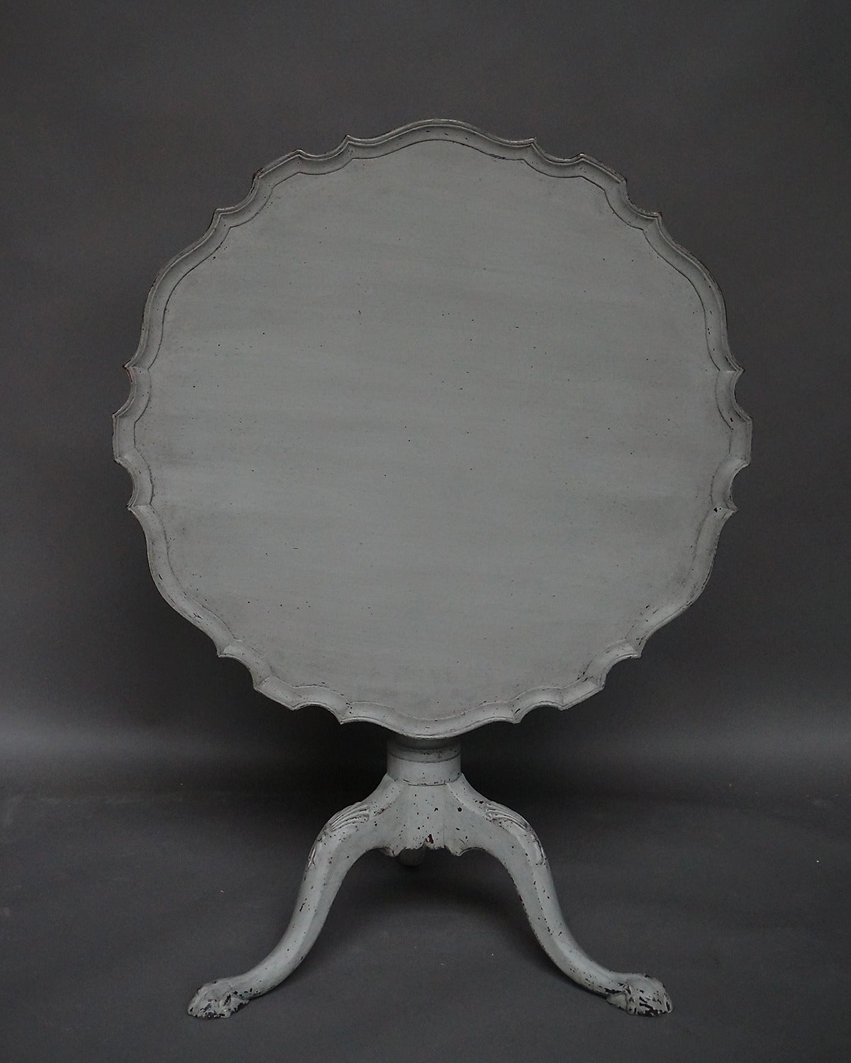 Swedish tilt-top table, circa 1840, with pedestal base with carved cabriole legs. The top has a shaped, pie-crust edge.