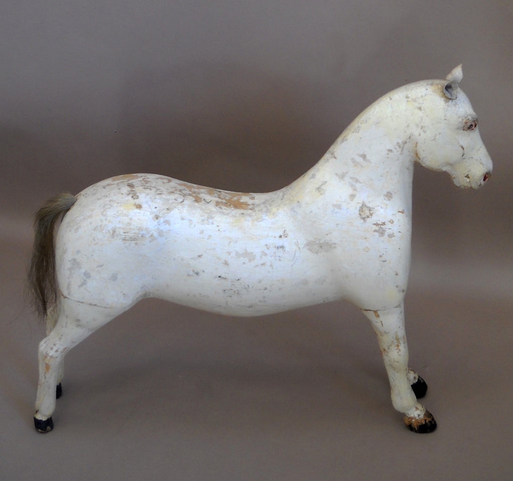 Small carved horse, Sweden circa 1880, with leather ears, black painted hooves and horse hair tail. Unusual pose with alert expression - this horse looks ready for anything!