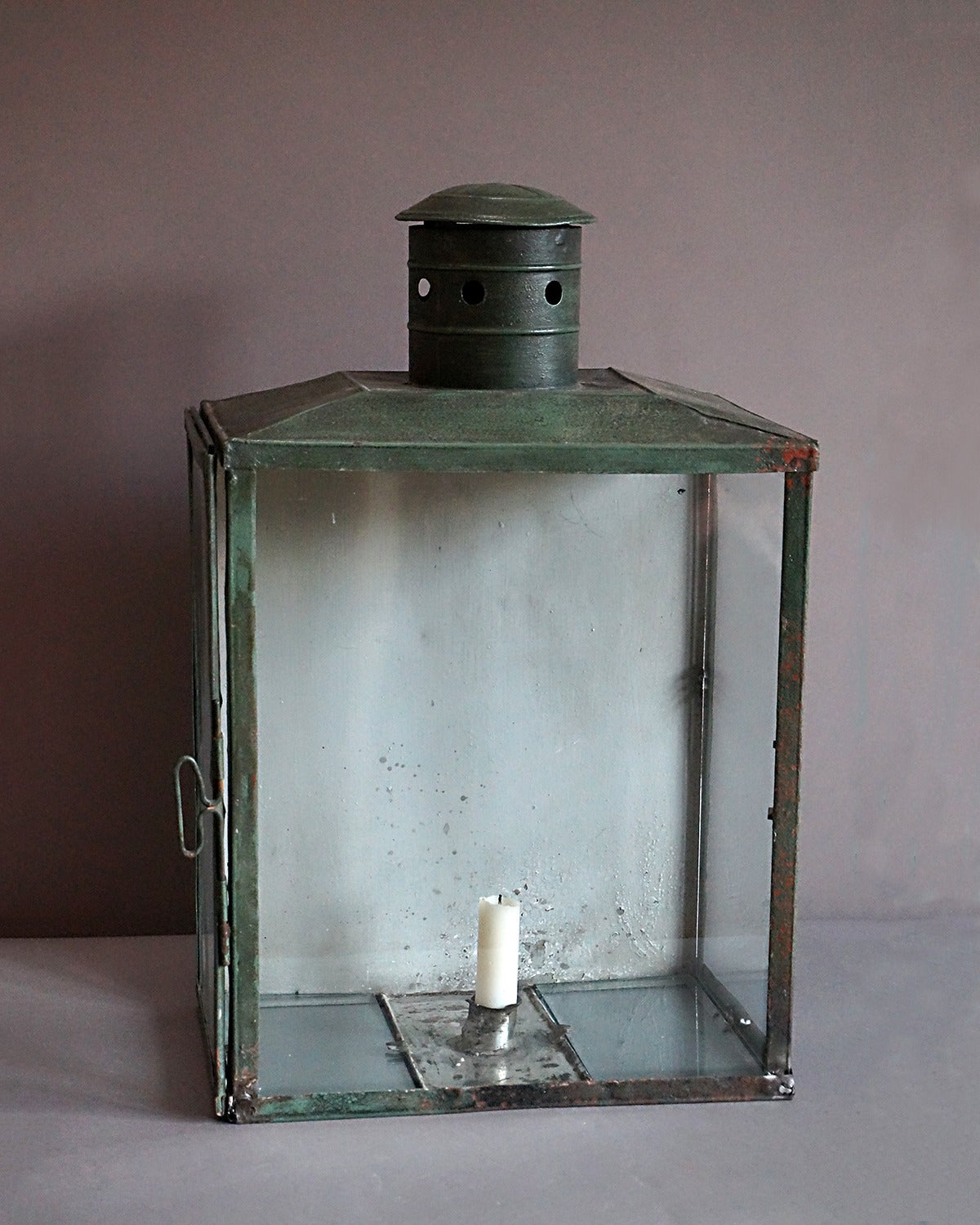 Swedish candle lantern, circa 1900, with glass front and sides. The back is solid with a strap to allow the lantern to be hung on or placed against a wall. In verdigris finish.