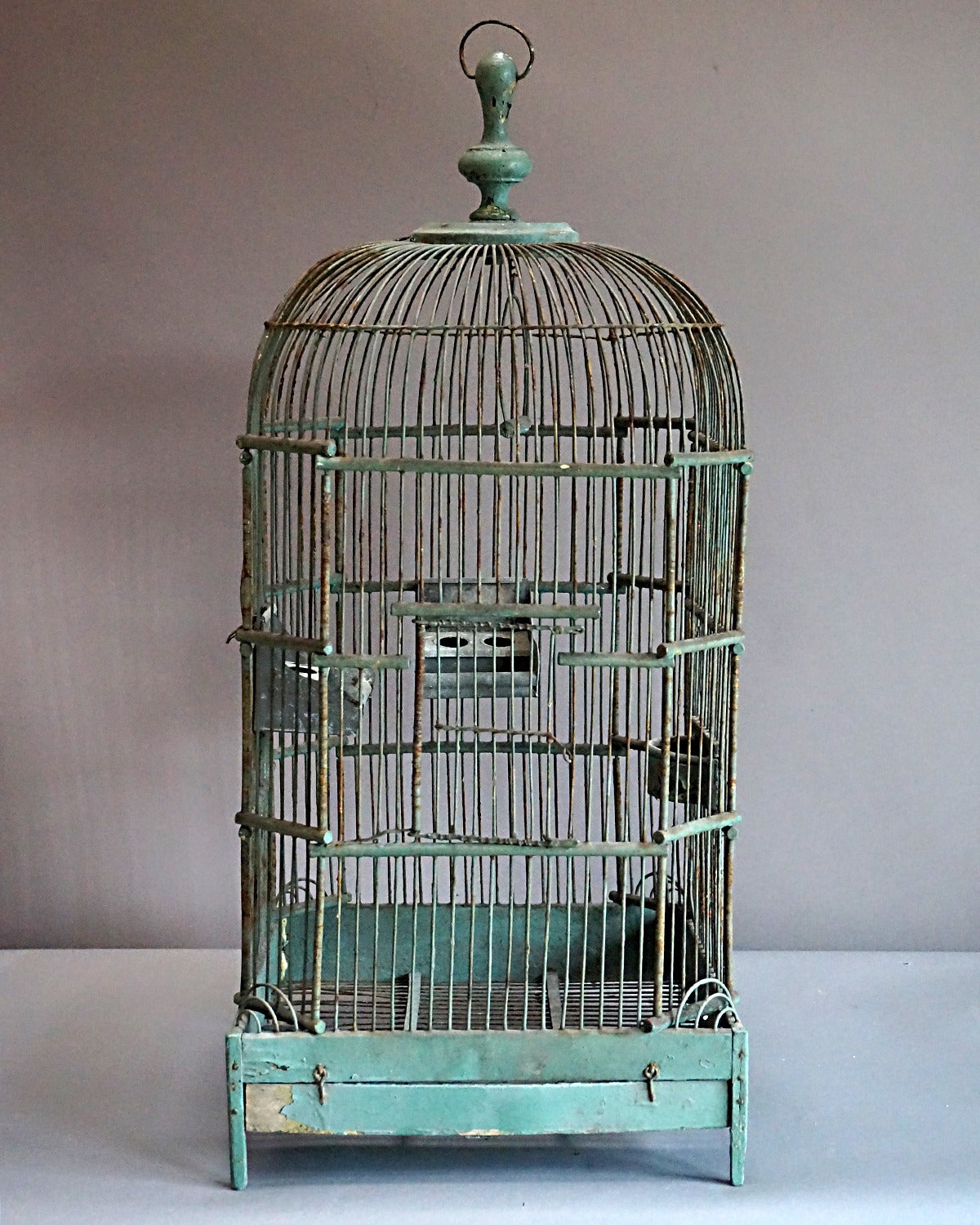 Wire bird cage, France, circa 1880, with wooden finial and base. Decorative wire work at the corners and great patina.