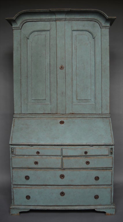 Two-part secretary with library, Sweden circa 1800. The upper section has three shelves and two box drawers behind raised panel doors. The lower section has a slant front over four half-width and two full-width drawers. The fitted interior features